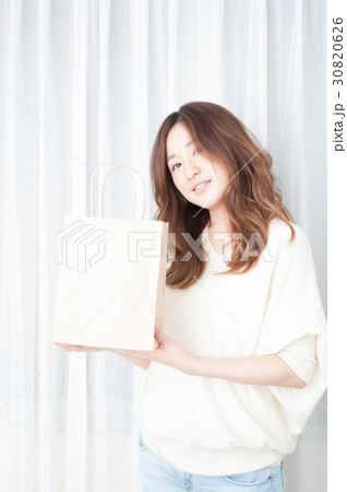紙袋を掲げる女性 30820626