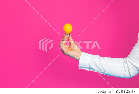photo of male hand holding yellow bulb photo of male hand holding yellow bulb 30822547