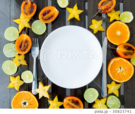 cut exotic fruits and crockery 30823741