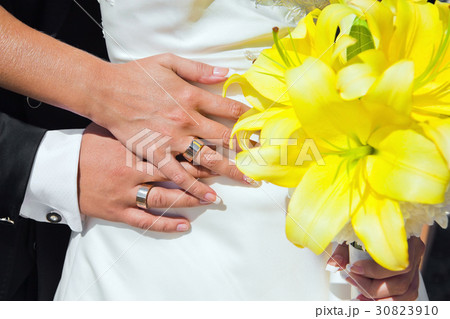 Bride and groom hands with wedding bouquet 30823910