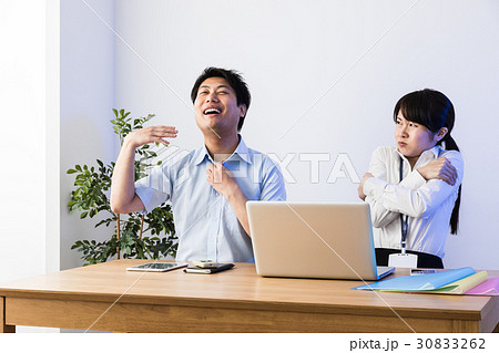 クーラーで涼むビジネスマンと凍えるビジネスウーマン、ノートパソコン 30833262