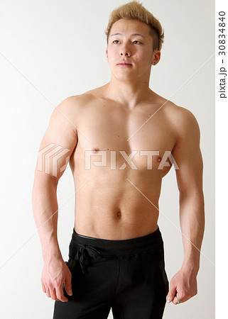 斜め上を見る筋肉質な若い男性の写真素材