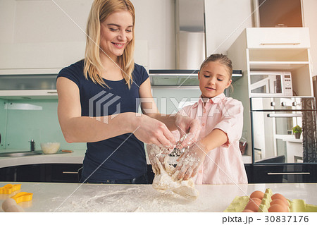 Young mother and daughter cooking dough together Young mother and daughter cooking dough together 30837176