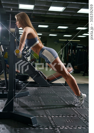 Young sexy fitness trainer doing push-ups in gym Young sexy fitness trainer doing push-ups in gym 30839269