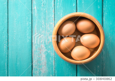 eggs in a wooden bowl on the ocean blue table eggs in a wooden bowl on the ocean blue table 30840862