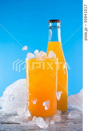 bottle of orange soda with glass and ice on a wood bottle of orange soda with glass and ice on a wood 30841017
