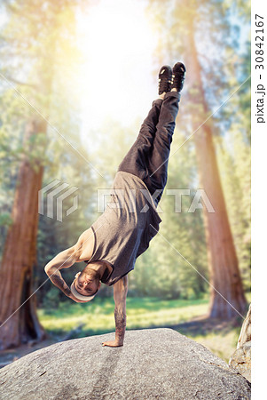 Breakdance performer, upside down motion in forest 30842167