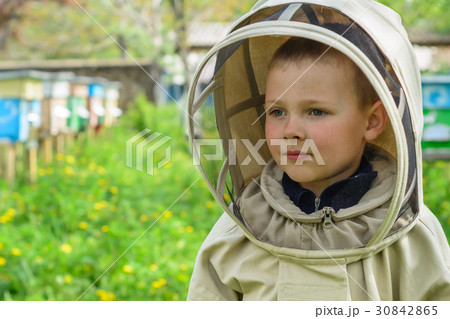 The boy in protective clothing beekeeper works on The boy in protective clothing beekeeper works on 30842865
