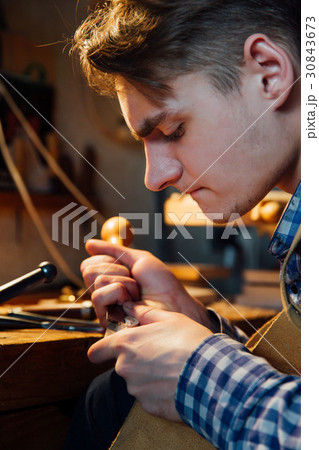 Master artisan luthier working on the creation of 30843673