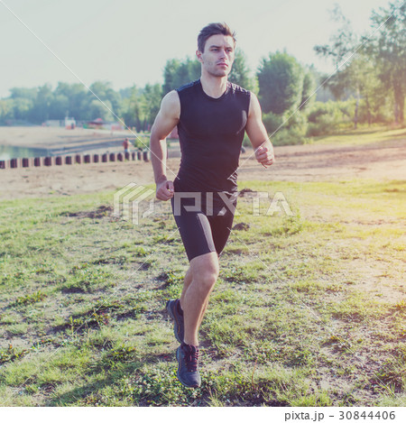 Fit man running outdoor in nature on beach Morning Fit man running outdoor in nature on beach Morning 30844406
