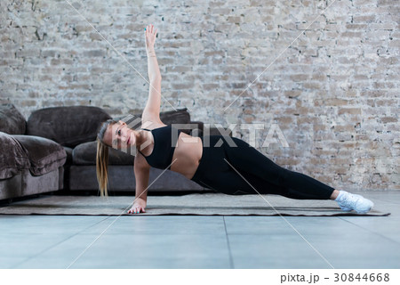 Strong Caucasian girl doing side plank exercise Strong Caucasian girl doing side plank exercise 30844668