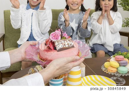 ホームパーティーイメージ ケーキを運ぶお母さん手元の写真素材