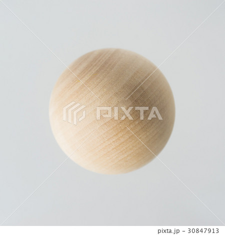 Floating wooden ball on grey background 30847913