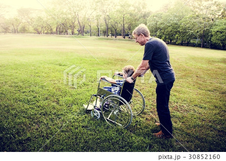 Little Boy On Wheelchair with Grandfather at Outdoors Park Little Boy On Wheelchair with Grandfather at Outdoors Park 30852160