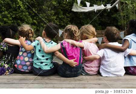 Group of children huddle together in rear view 30852170