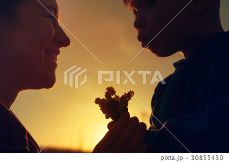 Mother and child with spring flowers at sunset Mother and child with spring flowers at sunset 30855430