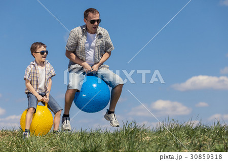 Father and son playing on the field at the day time. 30859318