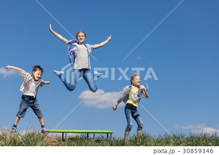 Brother and sisters playing on the field at the day time. Brother and sisters playing on the field at the day time. 30859346
