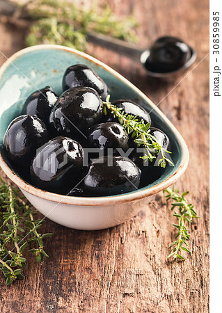 Bowl filled with fresh black olives 30859985