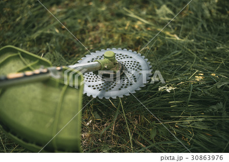Gasoline trimmer head on green grass. Gasoline trimmer head on green grass. 30863976