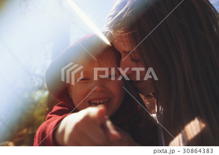 Young mother hugging her little son outdoors 30864383