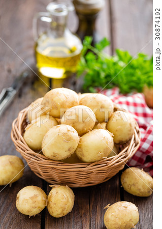 Raw potato in basket on wooden table closeup 30874192