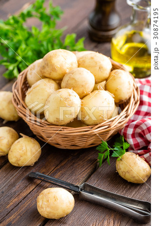 Raw potato in basket on wooden table closeup 30874195