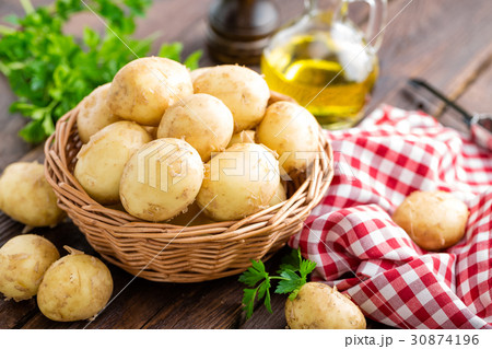 Raw potato in basket on wooden table closeup 30874196