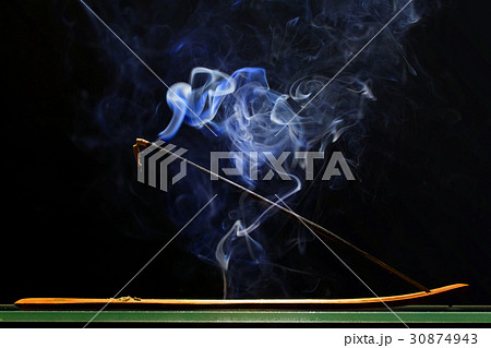 Incense stick smolders and emits intensive smoke 30874943