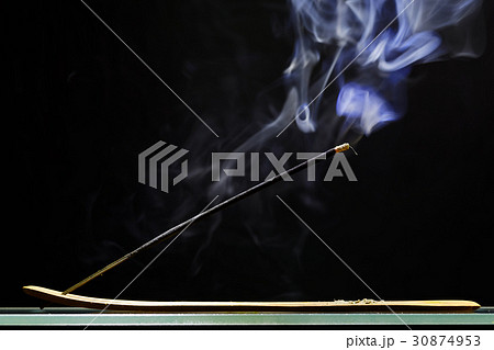 Incense stick smolders and emits intensive smoke Incense stick smolders and emits intensive smoke 30874953