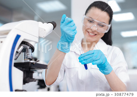 Delighted researcher taking blue liquid into Delighted researcher taking blue liquid into 30877479