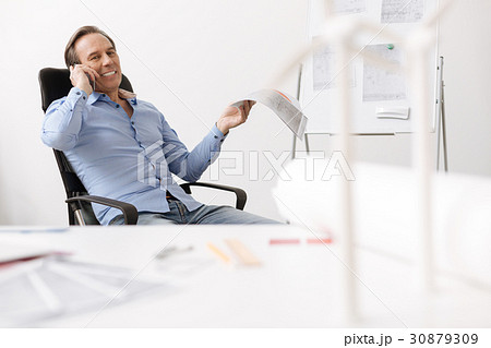 Positive engineer sitting in the office Positive engineer sitting in the office 30879309