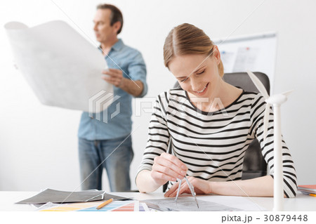 Positive professional woman engineer drawing with 30879448