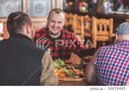 Cheerful men having fun together in pub 30879485