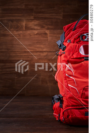 Big orange tourist backpack on the wooden Big orange tourist backpack on the wooden 30880279