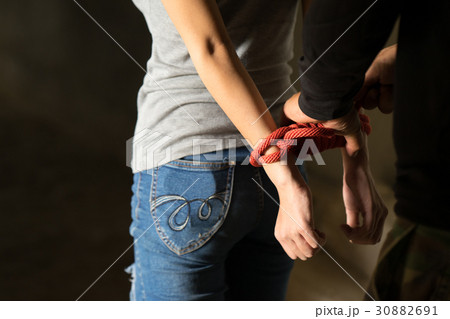 Tied rope hands of abused woman Tied rope hands of abused woman 30882691