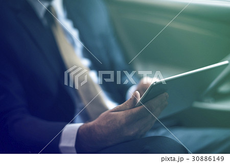 Businessman using digital tablet on backseat of the car 30886149