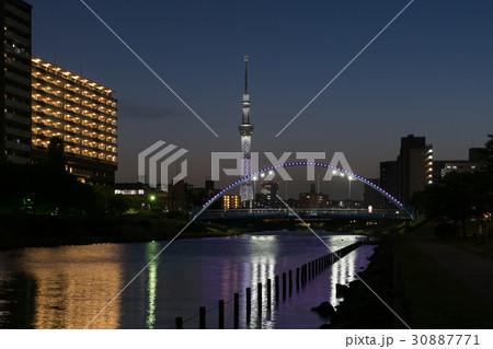 日没後に輝く白色の東京スカイツリーと旧中川ふれあい橋の夜景 30887771