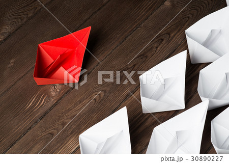 Business leadership concept with white and color paper boats on wooden table 30890227