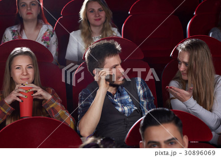 Brunet man talking at call phone at cinema hall. 30896069