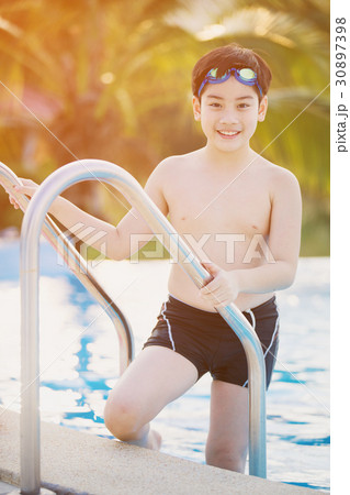 Happy asian boy in swimsuit coming up the pool 30897398