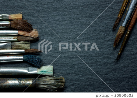 Used paint brushes lying on the side in row on 30900602