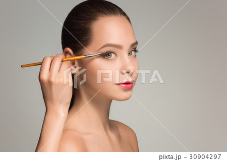 Beautiful female eyes with make-up and brush Beautiful female eyes with make-up and brush 30904297