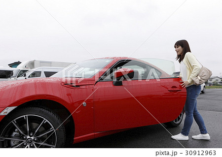 スポーツカーに乗り込む女性の写真素材