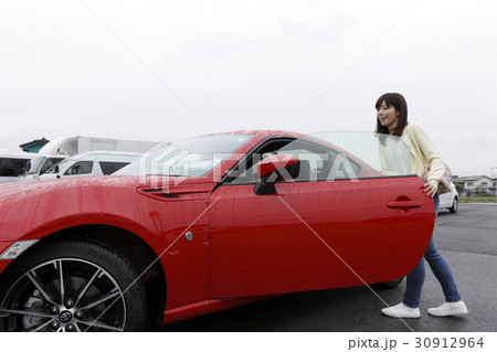 スポーツカーに乗り込む女性の写真素材