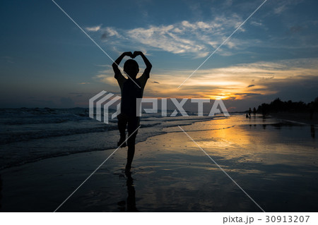 Silhouette of young boy making heart sign Silhouette of young boy making heart sign 30913207