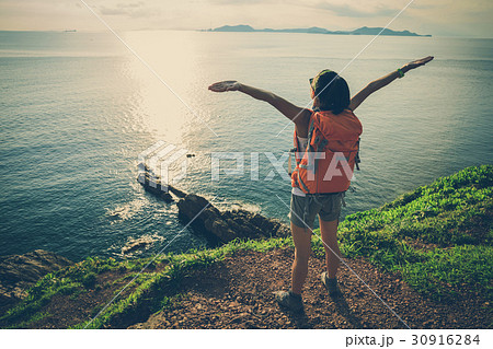 young woman hiking at sunrise seaside mountain young woman hiking at sunrise seaside mountain 30916284