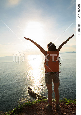 young woman hiking at sunrise seaside mountain young woman hiking at sunrise seaside mountain 30916286