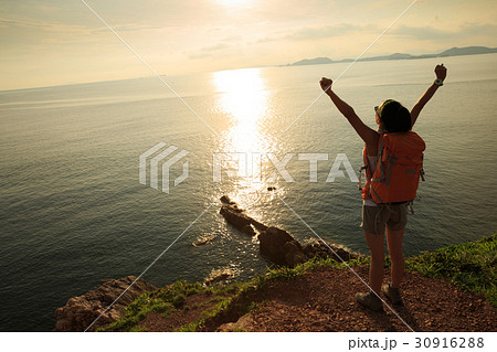 young woman hiking at sunrise seaside mountain young woman hiking at sunrise seaside mountain 30916288