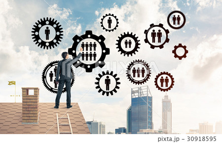 Businessman on house roof presenting teamwork and connection con Businessman on house roof presenting teamwork and connection con 30918595